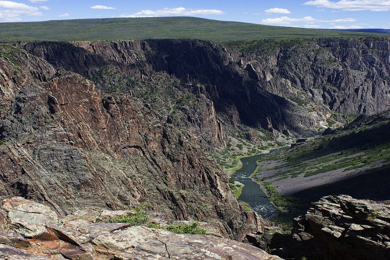 Deep narrow gorge of Black Canyon of the Gunnison with dark rock walls