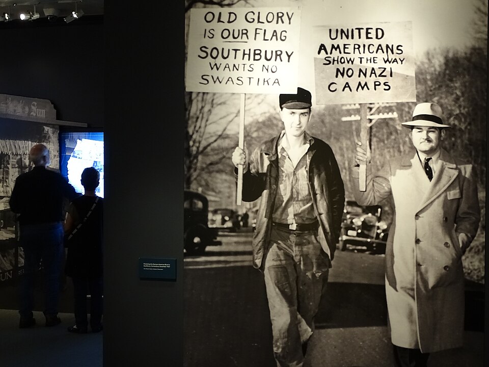 Solemn memorial exhibit with historical artifacts and photographs