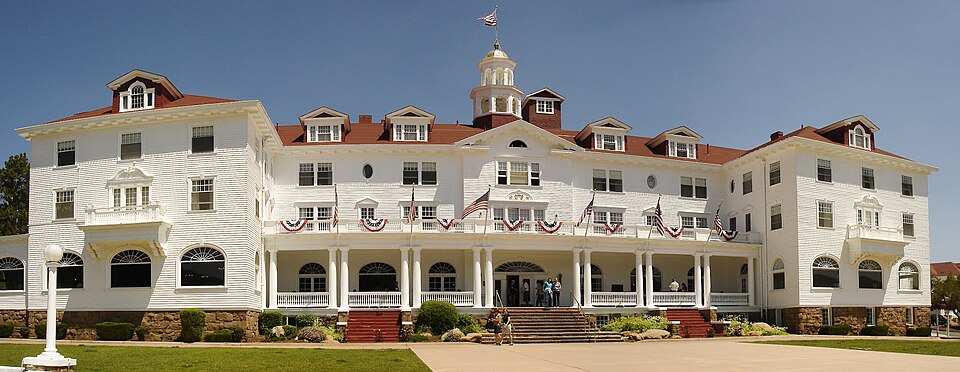 Grand white colonial hotel with mountains behind it